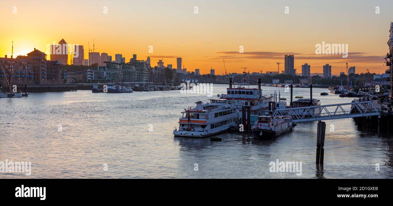 Londra - Le navi ormeggiate al molo e il Canary Wharf in mattina. Foto Stock