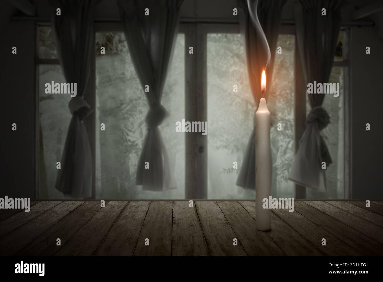 Una candela che brucia in una casa abbandonata. Concetto di Halloween Foto Stock