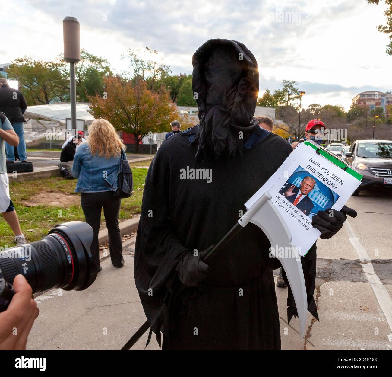 Bethesda, MD, USA, 5 ottobre 2020. Nella foto: Una persona vestita come il grim Reaper porta la falce e una clipboard con una foto di Donal Trump e il titolo, 'avete visto questa persona?' Sotto la foto, il foglio indica che è stato 'ultimo visto 4 ottobre mettere in pericolo la vita degli altri per vanità.' I sostenitori di Trump si sono riuniti fuori dal Walter Reed National Military Medical Center, dove è stato ricoverato in ospedale per la covid-19. I fan del presidente sono venuti a dimostrare il loro sostegno durante i quattro giorni in cui è rimasto in ospedale dopo aver contratto il novo coronavirus. Credit: Alison C Bailey/Alamy Live Foto Stock