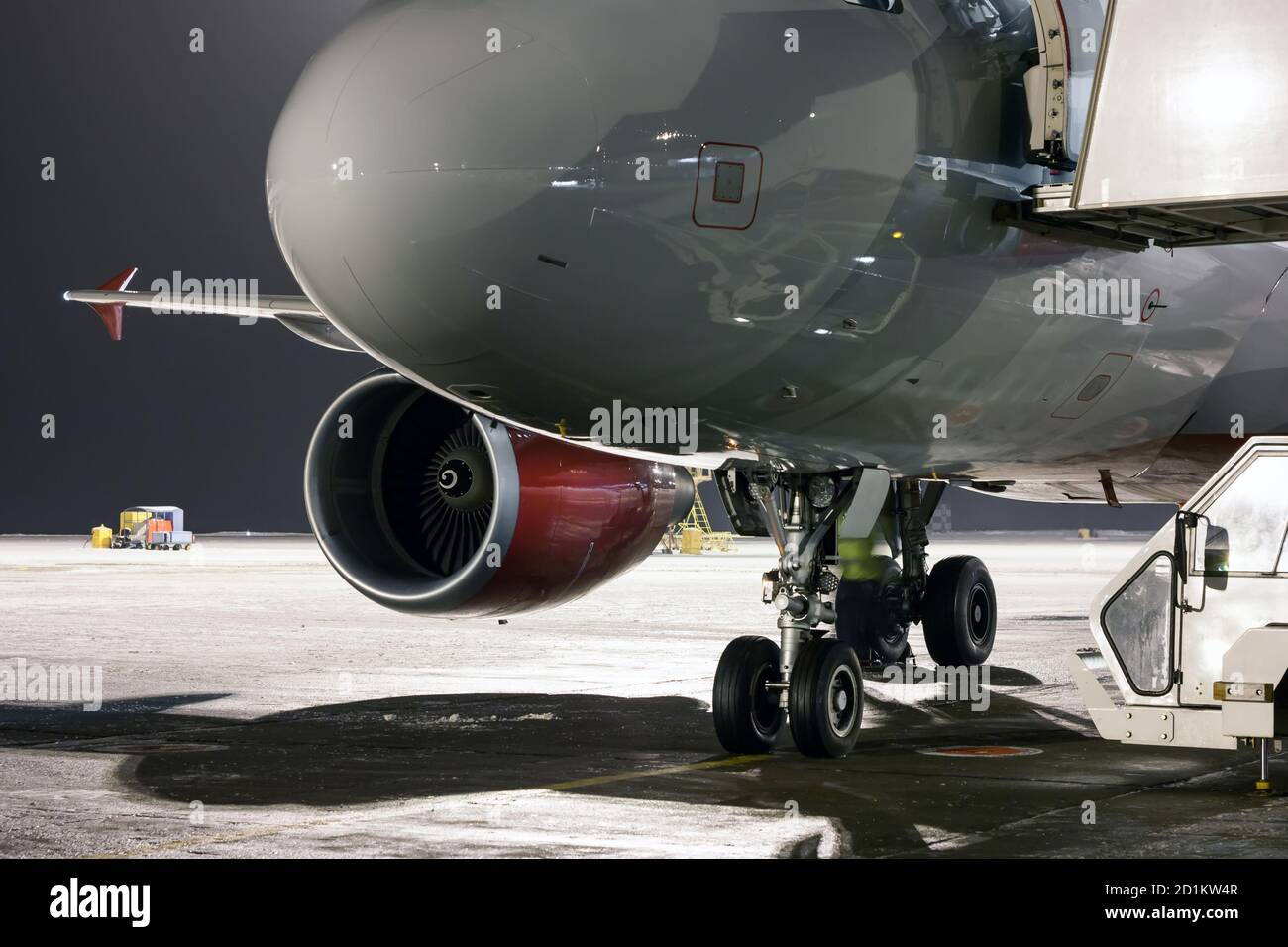 Naso, motore e attrezzi di atterraggio dell'aereo passeggeri al grembiule notturno dell'aeroporto Foto Stock