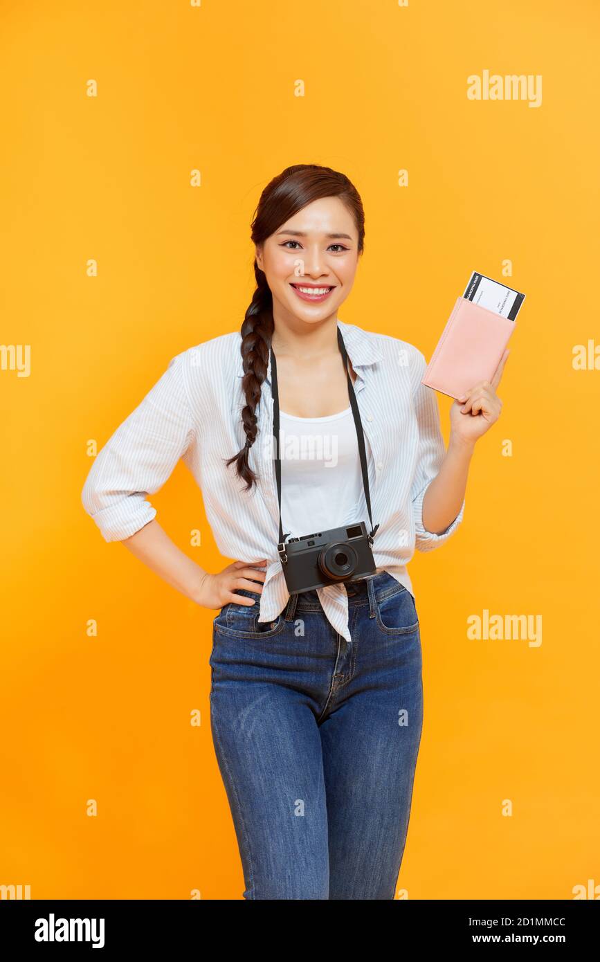 Ritratto di giovane donna asiatica che tiene il passaporto e sorridi. Persone felici e concetto di viaggio. Foto Stock