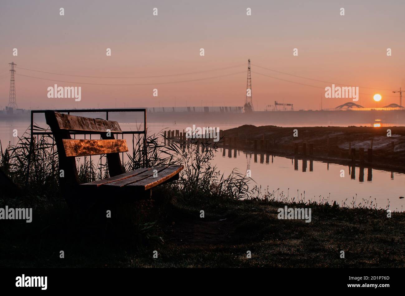 Panchina presso un lago durante l'alba Foto Stock