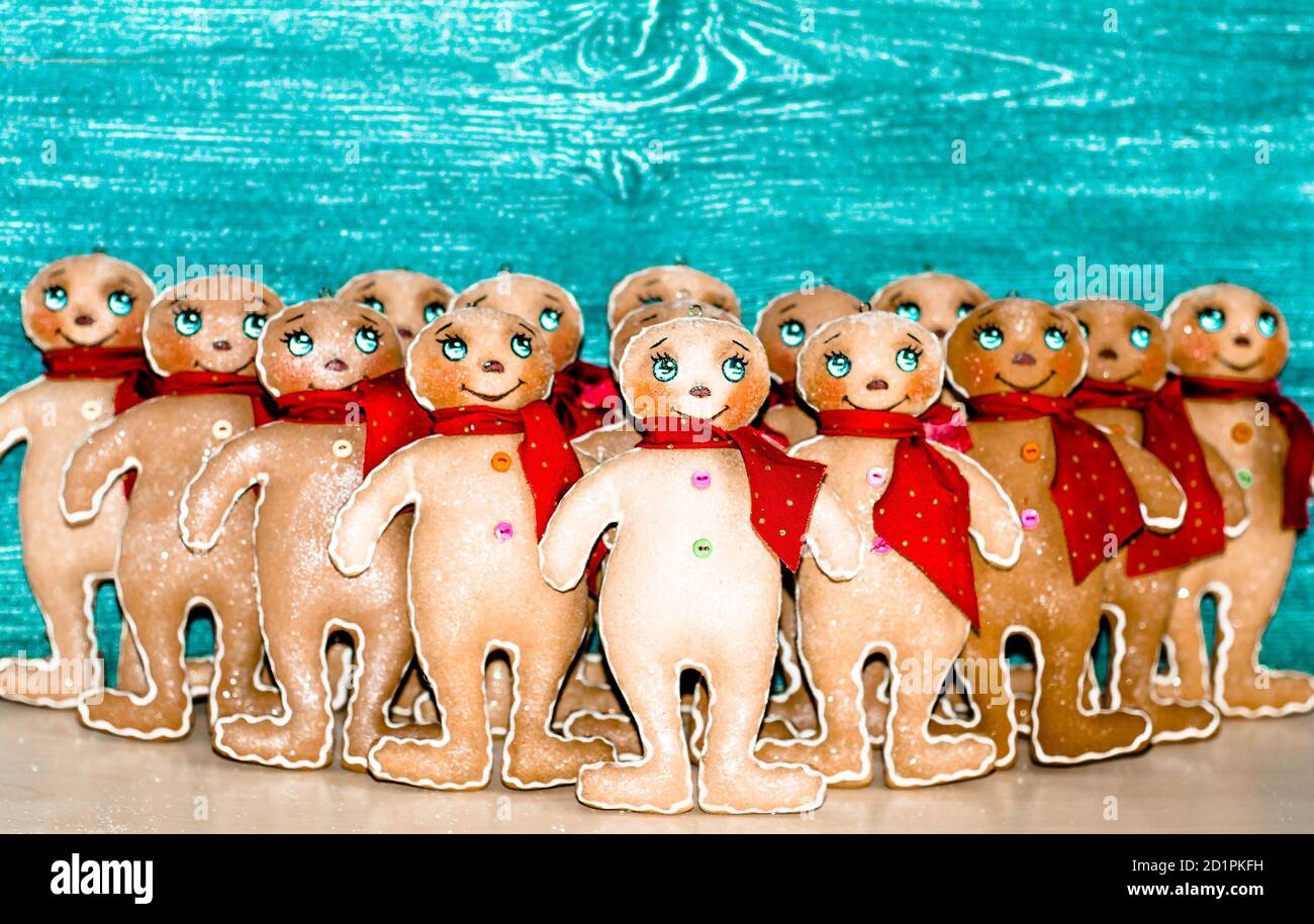 Un sacco di pan di zenzero in sciarpe rosse su uno sfondo grigio-blu . Decorazioni natalizie per la casa. Giocattolo di Natale. Foto Stock