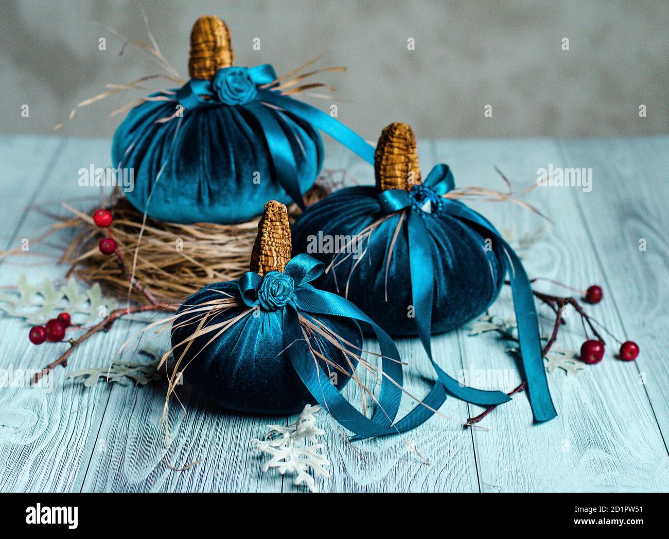 Belle zucche blu in tessuto vellutato sono decorate con vari elementi e nastri . Arredamento per la vacanza di Halloween. Decorazioni natalizie Foto Stock