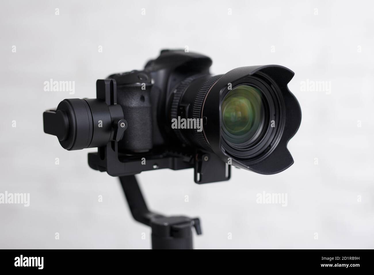 kit per fotografia o videografia - primo piano della moderna reflex digitale telecamera sullo stabilizzatore cardanico a 3 assi su sfondo grigio Foto Stock