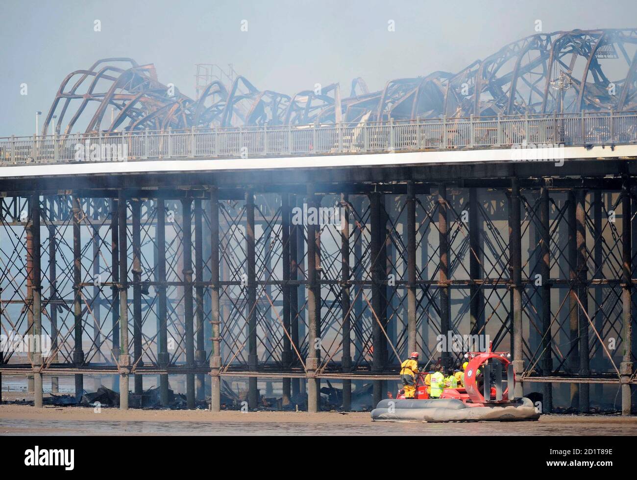 I lavoratori dei servizi di emergenza ispezionano il Grand Pier a Weston-Super-Mare, nel sud-ovest dell'Inghilterra, il 28 luglio 2008. I vigili del fuoco sono stati chiamati a una grande boccata che ha attraversato lo storico molo presso la località balneare Somerset di Weston-super-Mare lunedì, ha detto la polizia. Fiamme e spesso fumo nero hanno travolto la struttura e si poteva vedere dall'autostrada M5, a diverse miglia dalla costa, ha detto una portavoce vigili del fuoco. REUTERS/Toby Melville (GRAN BRETAGNA) Foto Stock