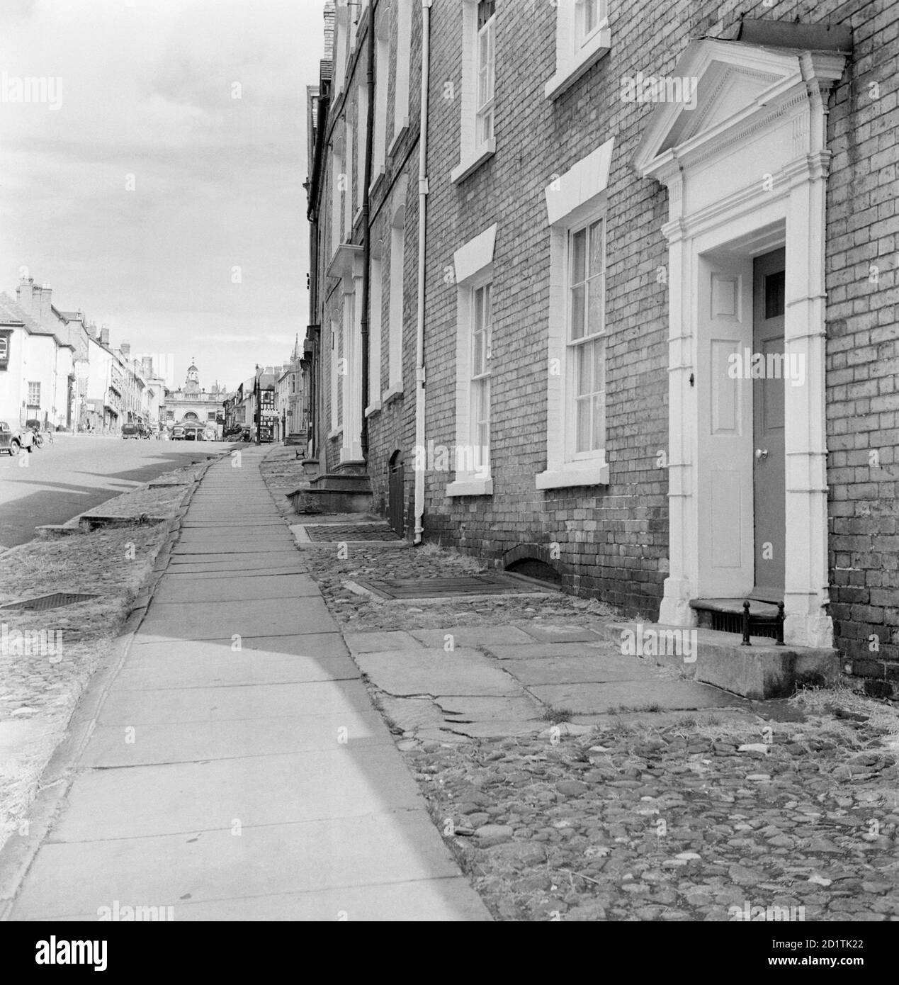 BROAD STREET, Ludlow, Shropshire. Una vista lungo Broad Street a Ludlow guardando verso la Croce del burro (o municipio) in lontananza. Questo è stato costruito in stile classico da William Baker nel 1743. Fotografato da Eric de Mare tra il 1945 e il 1980. Foto Stock