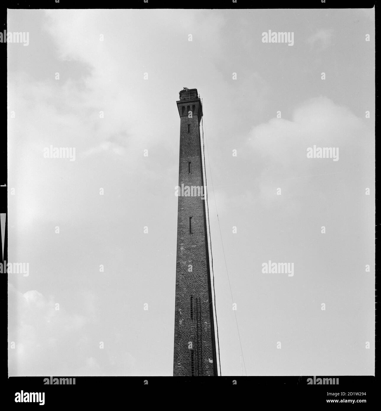 Il camino di Salt's Mill, con due steeplejacks appena visibili lavorando in cima, Saltair, Shipley, Bradford, West Yorkshire, Regno Unito. Foto Stock