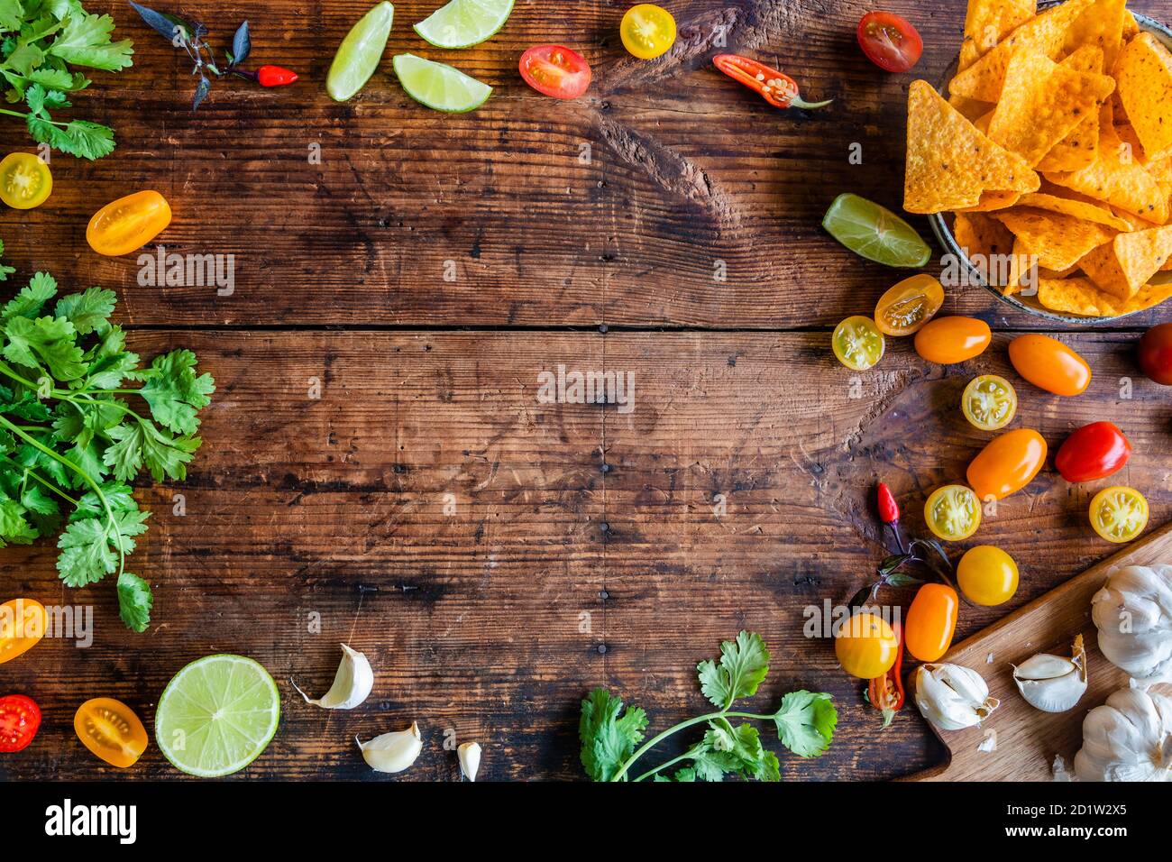 Calce, coriandolo, peperoncino, nachos sfondo con spazio copia. Ingredienti per salsa di salsa al Pico de gallo o altri piatti messicani o latinoamericani. Su una ruggine Foto Stock