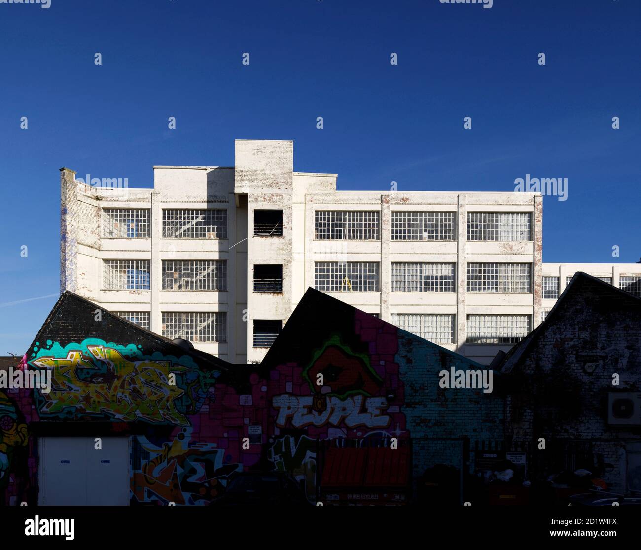 Vista esterna della fabbrica abbandonata con pareti ricoperte di graffiti. Foto Stock