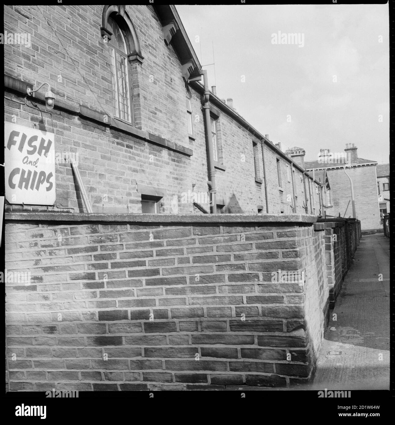 Una vista da Upper Mary Street guardando ad est lungo il vicolo tra Titus Street e Constance Street, Saltaire, Shipley, Bradford, West Yorkshire, Regno Unito. Foto Stock