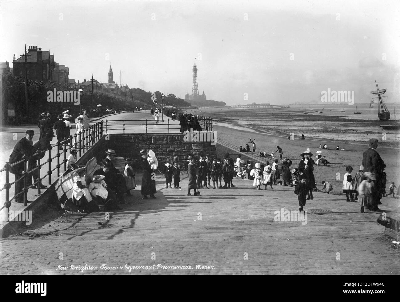 Folla sul lungomare di Egremont con la New Brighton Tower sullo sfondo. Foto Stock