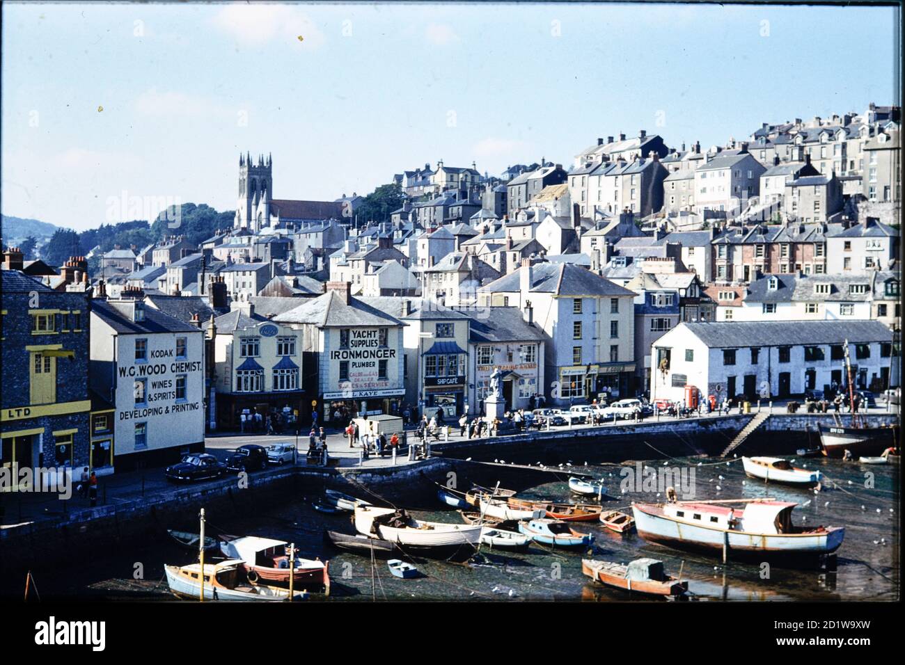 The Strand, Brixham, Torbay, Devon. Lo Strand, con le barche ormeggiate nel porto di Brixham, e la città che sorge sulla collina alle spalle, vista da King Street. Foto Stock