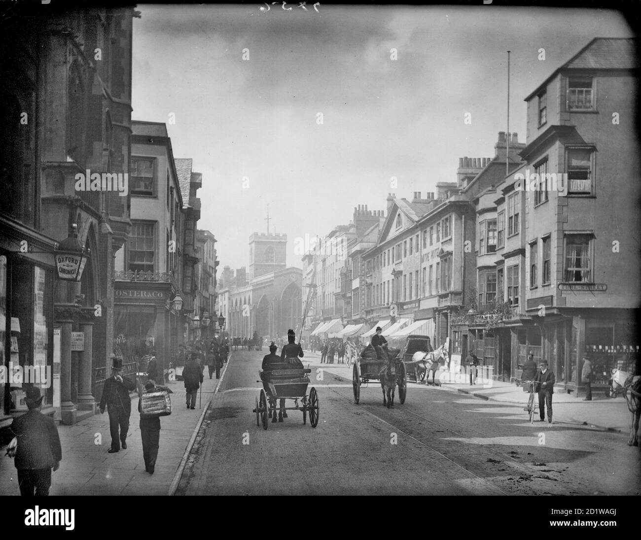 High Street, Oxford, Oxfordshire. Guardando la strada con la chiesa alla fine prima che fu demolita in gran parte nel 1896 per far posto al piano di miglioramento Carfax, ampliando l'area per il traffico. Foto Stock