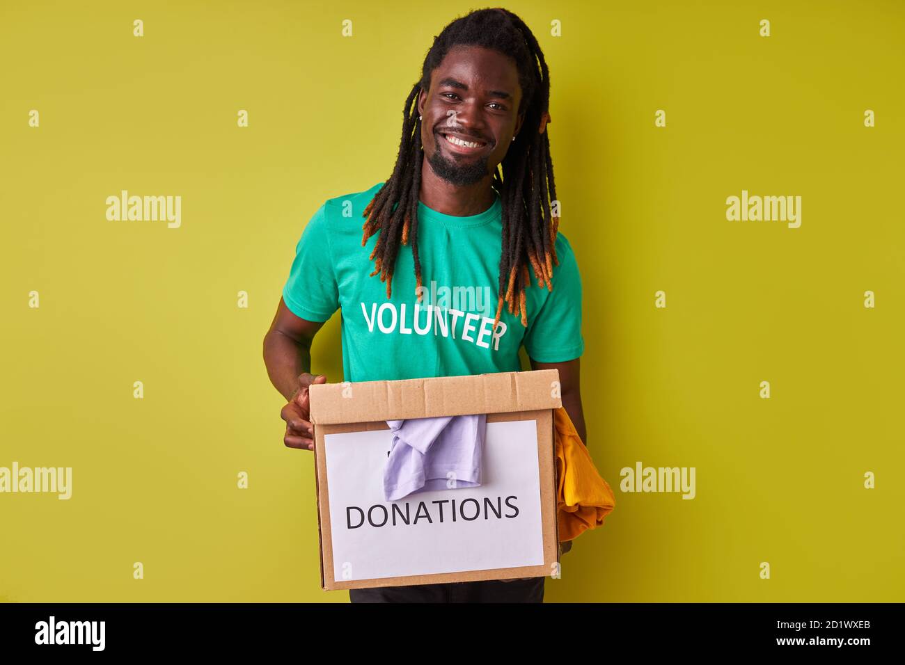 giovane africano che tiene una scatola donata con vestiti, concetto di organizzazione di beneficenza, concetto di donazione Foto Stock