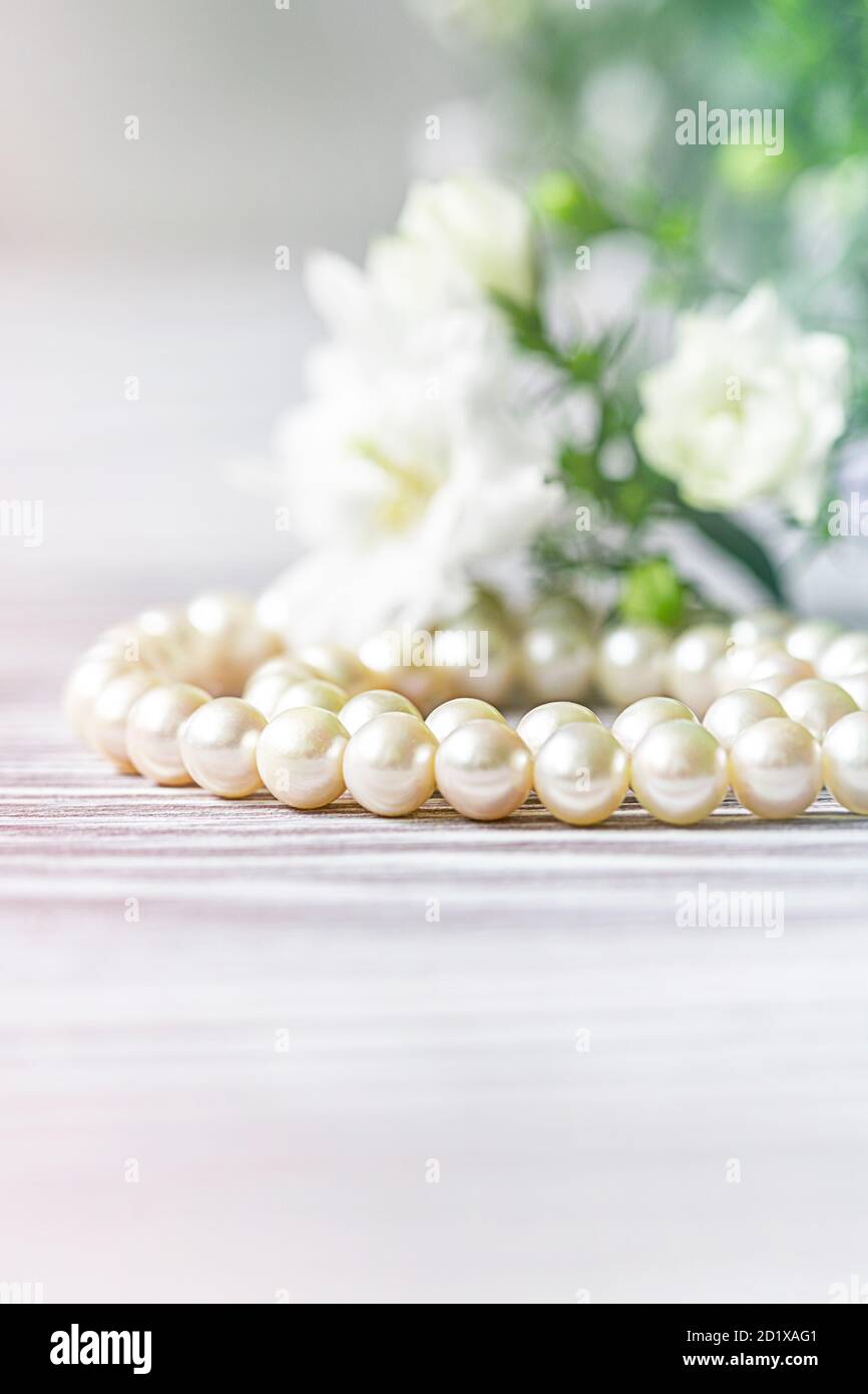 Bella collana di perle bianche con fiori bianchi. Foto Stock