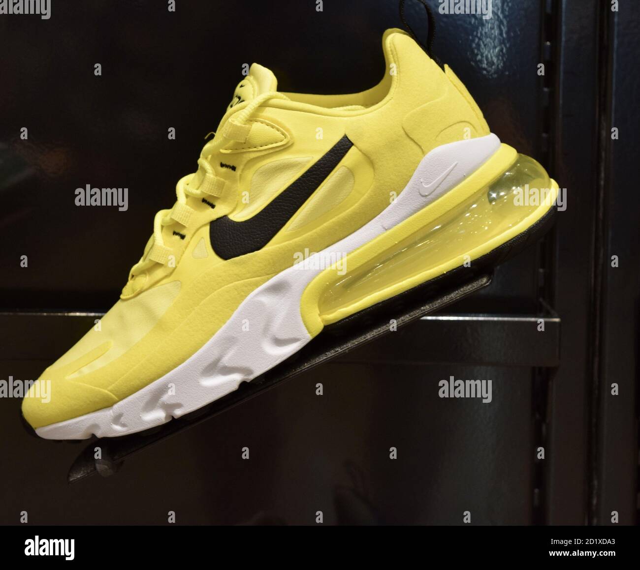 FRESNO, STATI UNITI - 01 settembre 2020: Una foto di una scarpa Nike giallo molto brillante con il logo Nike nero e il fondo bianco e giallo contro una w nera Foto Stock