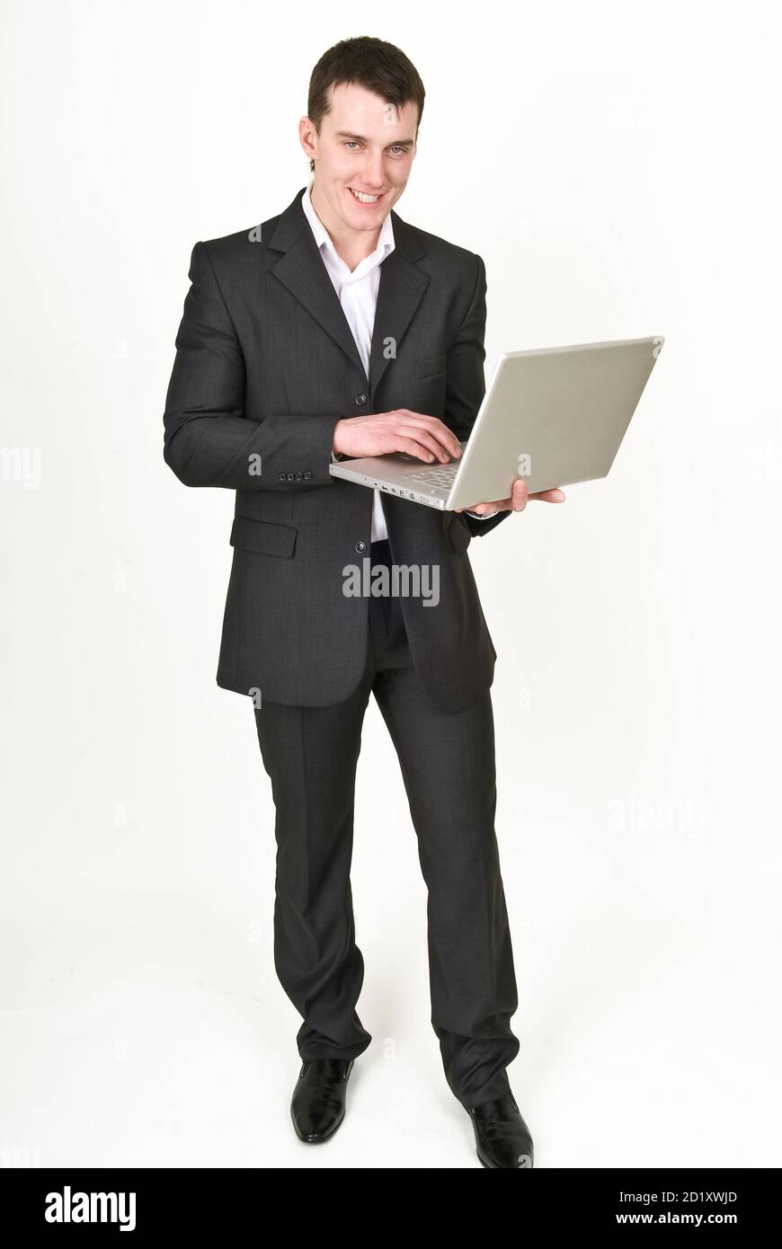 Giovane uomo in tuta da lavoro con computer portatile Foto Stock