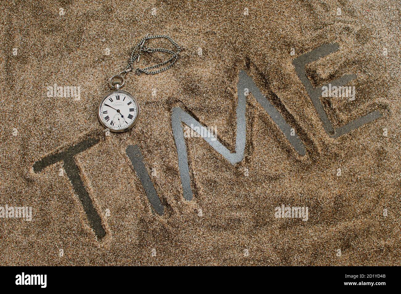 Vecchio orologio tascabile messo sulla parola tempo. Lettere temporali in nero. Numeri romani che indicano il tempo Foto Stock