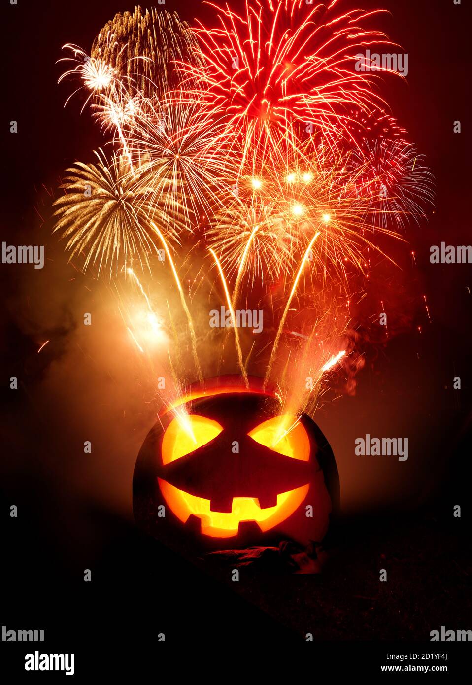 Sfondo della festa di Halloween. Un jack o lanterna intagliato zucca incandescente con fuochi d'artificio che vengono rilasciati nel cielo notturno. Foto composito. Foto Stock