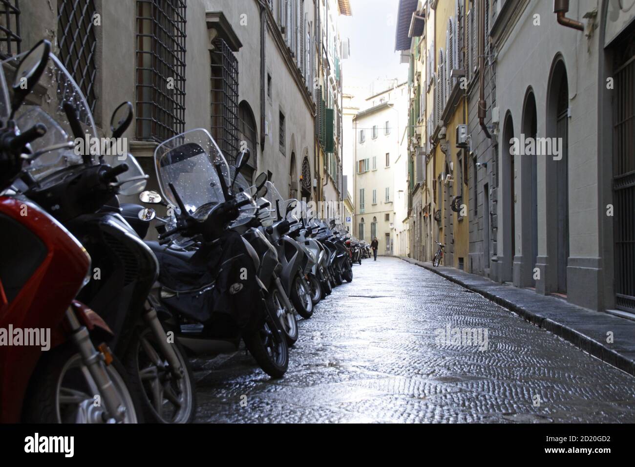 Piccolo vicolo con una fila di motociclette parcheggiate a Firenze, Italia Foto Stock