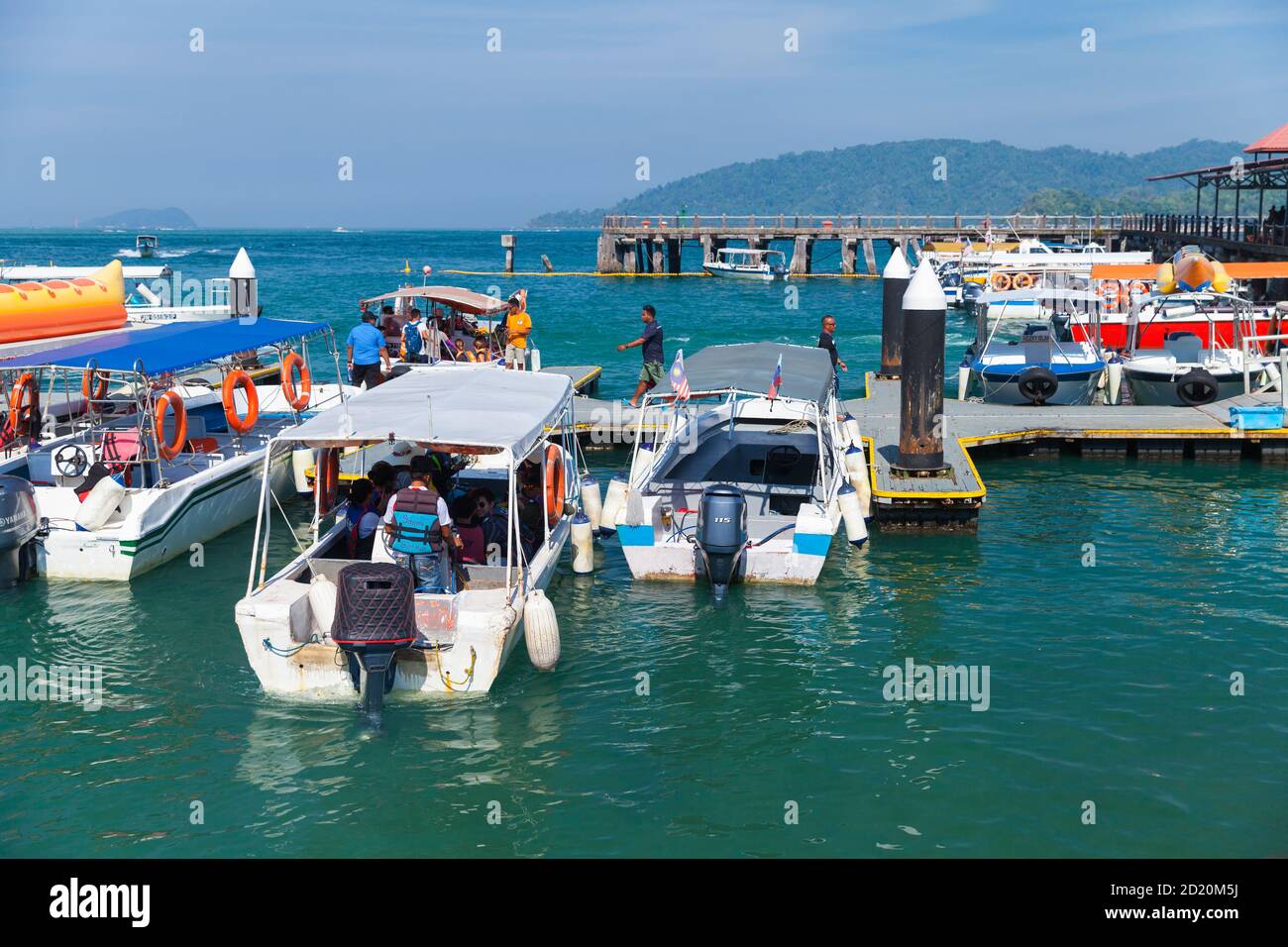 Kota Kinabalu, Malesia - 17 marzo 2019: Barche a motore da diporto con passeggeri sono ormeggiate vicino al terminal dei traghetti di Jesselton Point in giornata di sole Foto Stock