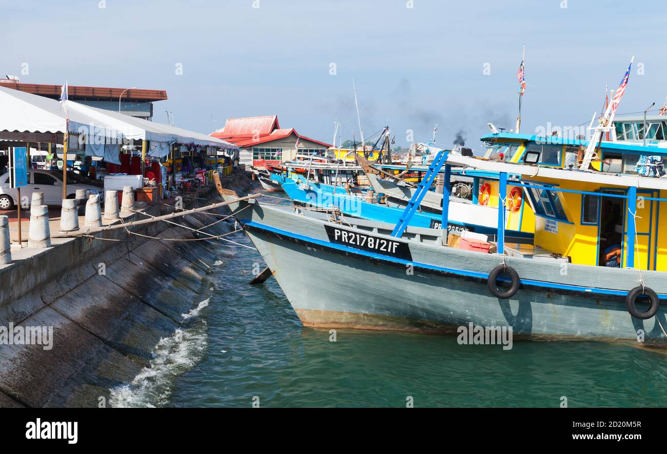 Kota Kinabalu, Malesia - 17 marzo 2019: Barche da pesca colorate ormeggiate vicino al mercato del pesce KK in giornata di sole Foto Stock