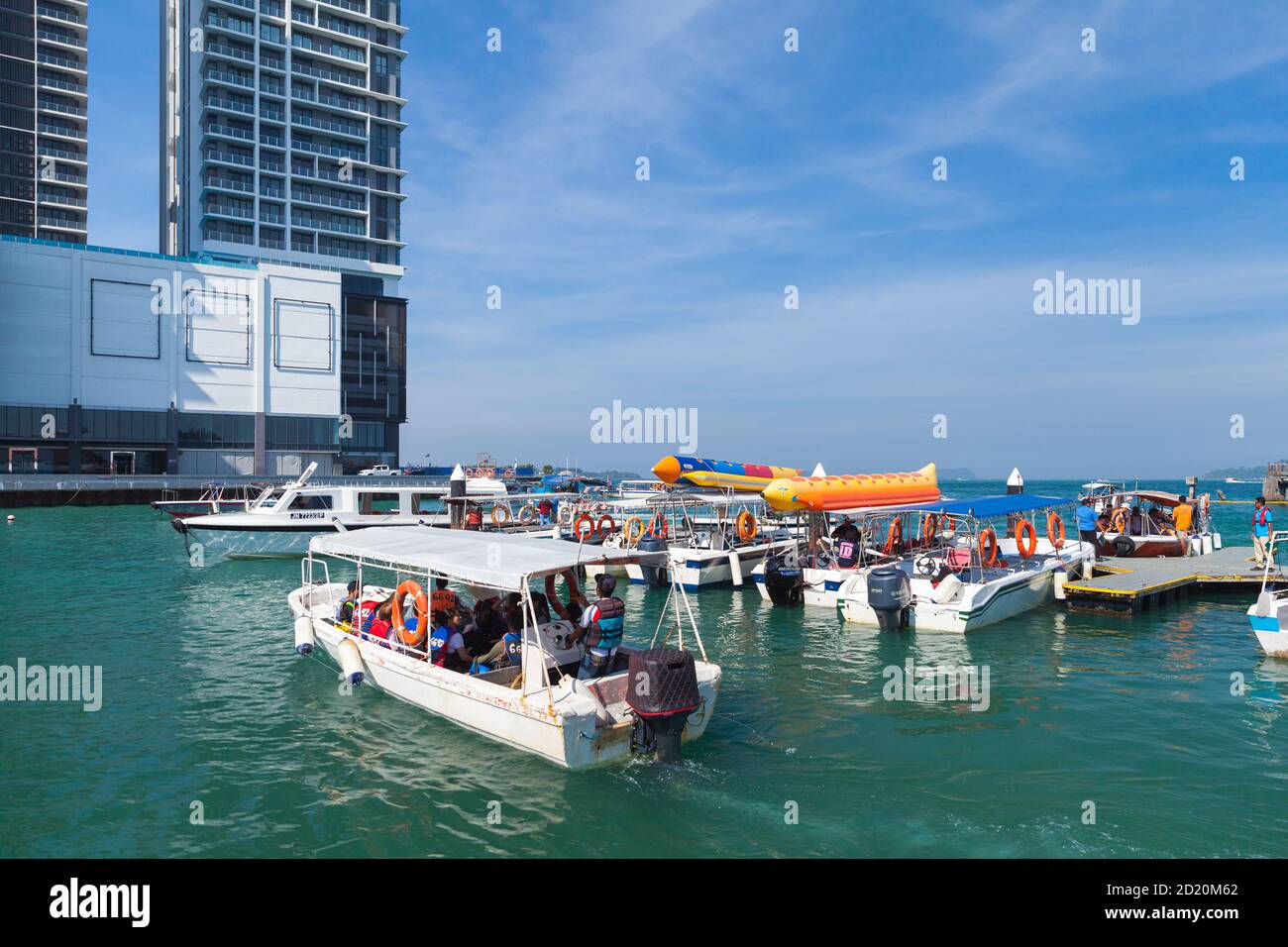 Kota Kinabalu, Malesia - 17 marzo 2019: Barche a motore bianche con passeggeri sono vicino al terminal dei traghetti di Jesselton Point in giornata di sole Foto Stock