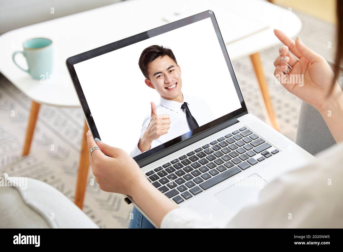 giovane donna asiatica d'affari che lavora a casa incontro con la collega online tramite videochiamata con computer portatile Foto Stock