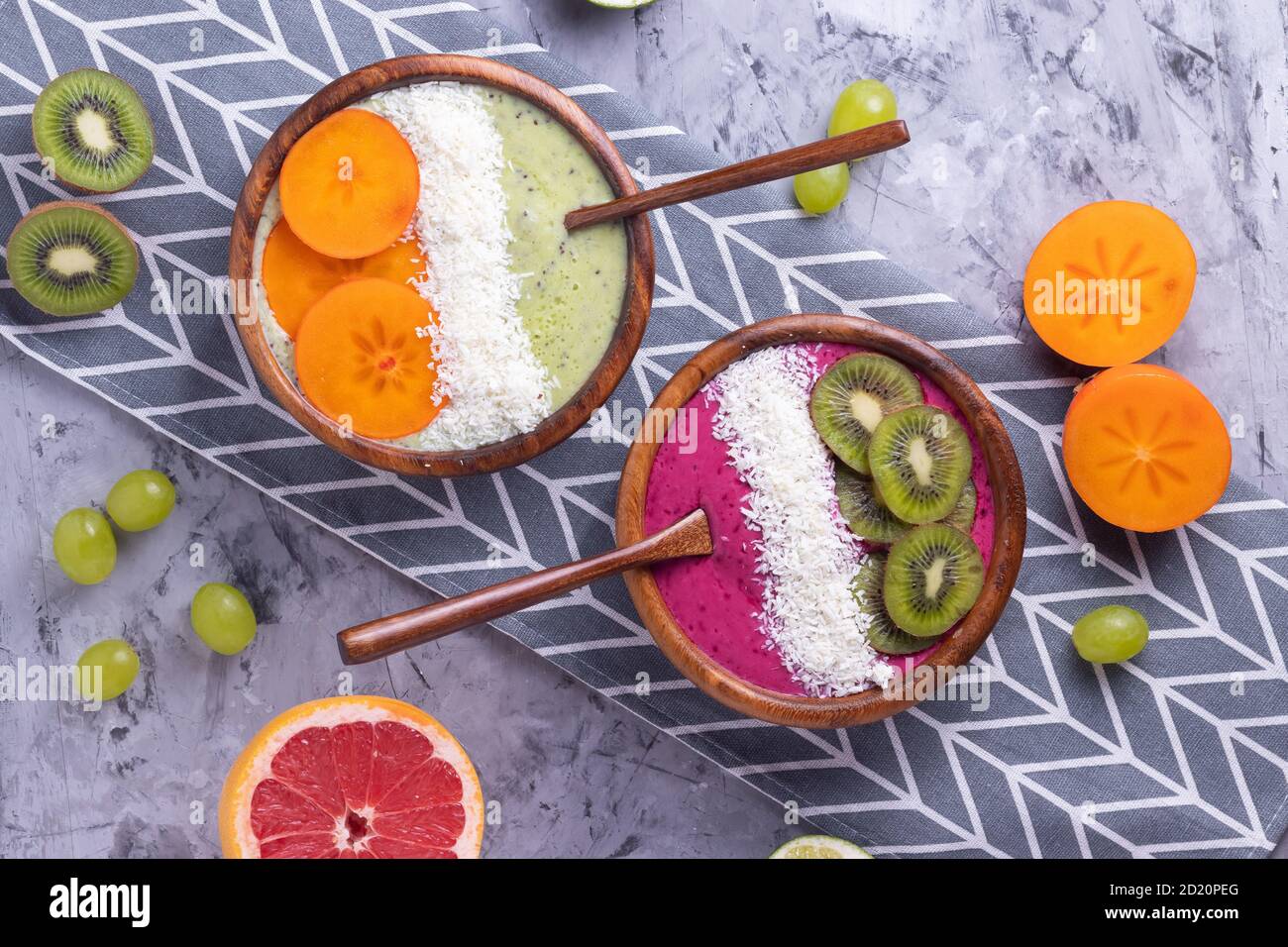 Frullato vegetariano di frutta con kiwi, ribes nero, mirtillo, prugna, persimmon, uva, pompelmo, yogurt e panna, cosparso di cocco Foto Stock