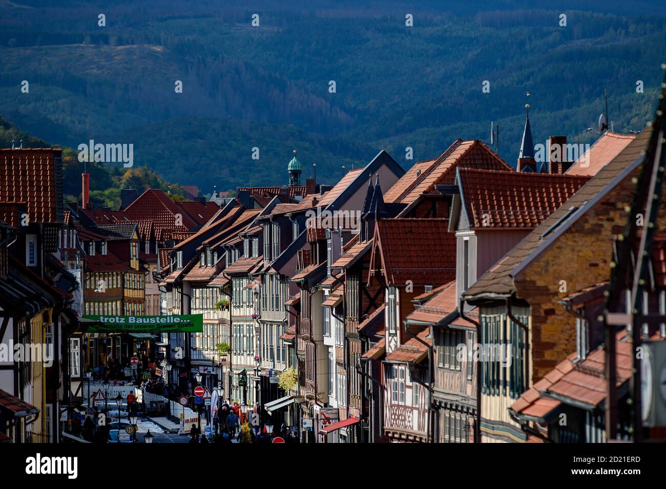 Wernigerode, Germania. 06 ottobre 2020. Le facciate di colore chiaro delle case a graticcio e i tetti rossi della città si distinguono contro la foresta che oscura e bluisce sulle pendici dei monti Harz. È diventato autunno e il sole è già intorno al già notevolmente più basso che in estate, che solo poche settimane fa si è trasformato in autunno. Nei giorni a venire si prevede che il cielo si apra di nuovo e di nuovo e il sole verrà fuori. Tutto in tutto, tuttavia, rimarrà un duro mix di sole, nuvole, docce e vento. Credit: Klaus-Dietmar Gabbert/dpa-Zentralbild/ZB/dpa/Alamy Live News Foto Stock