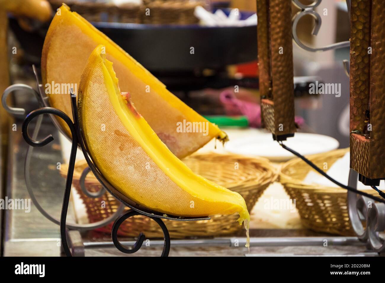 Raclette (tradizionale piatto di formaggio fuso) al mercatino di Natale di Parigi. Gocciolare il formaggio giallo. Astratto cibo tradizionale sfondo. Tou del buongustai Foto Stock
