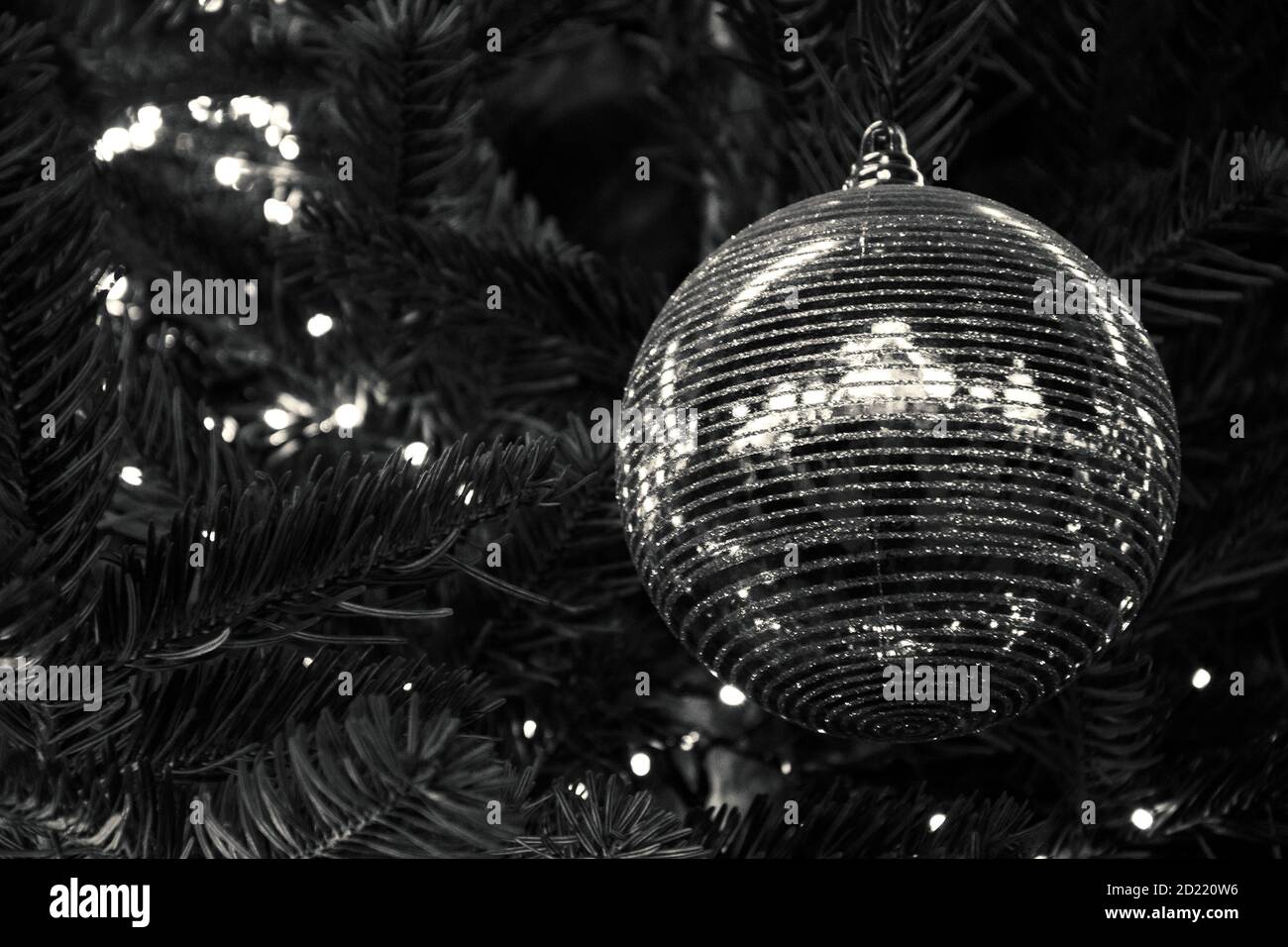 Palle di Natale a righe lucenti sull'albero di Natale e le luci di Natale Garland. Xmas sfondo. Concetto di vacanza invernale. Riflessione. Bokeh. Selezione f Foto Stock