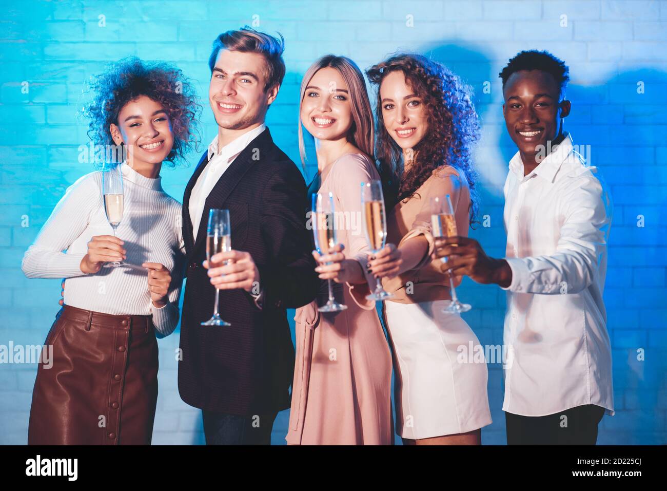 Sorridente colleghi che tiene bicchieri di champagne per festeggiare l'evento aziendale in piedi al coperto Foto Stock