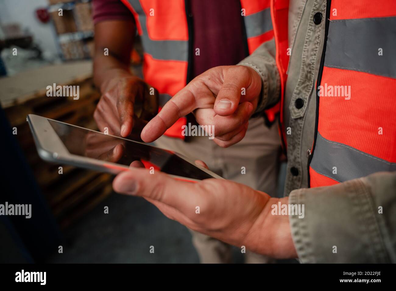 Primo piano dei lavoratori che scelgono le immagini su dispositivi digitali in magazzino Foto Stock