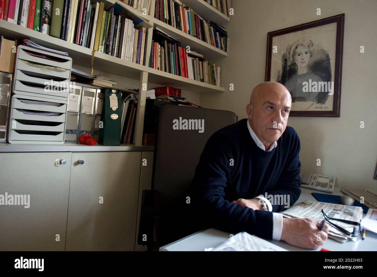 Gattinoni fashion house chairman Stefano Dominella speaks to a reporter  under a portrait of founder Fernanda Gattinoni in his office in Rome  February 18, 2009. Italy is promising aid to everyone from