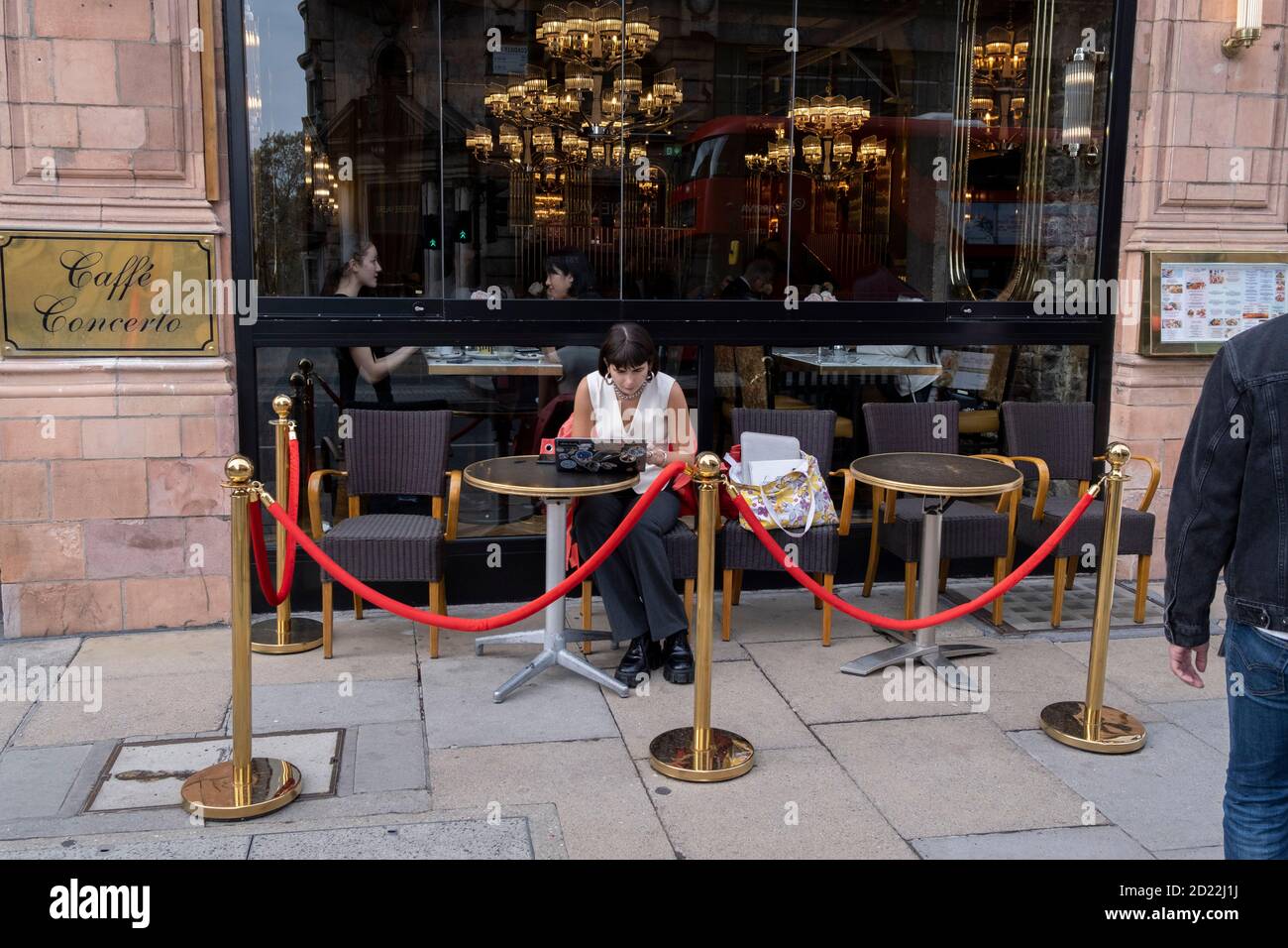 Una donna si siede con il suo laptop al di fuori del caffè Concerto su Piccadilly durante la seconda (autunno) punta della pandemia di Coronavirus, il 5 ottobre 2020, a Londra, Inghilterra. Foto Stock