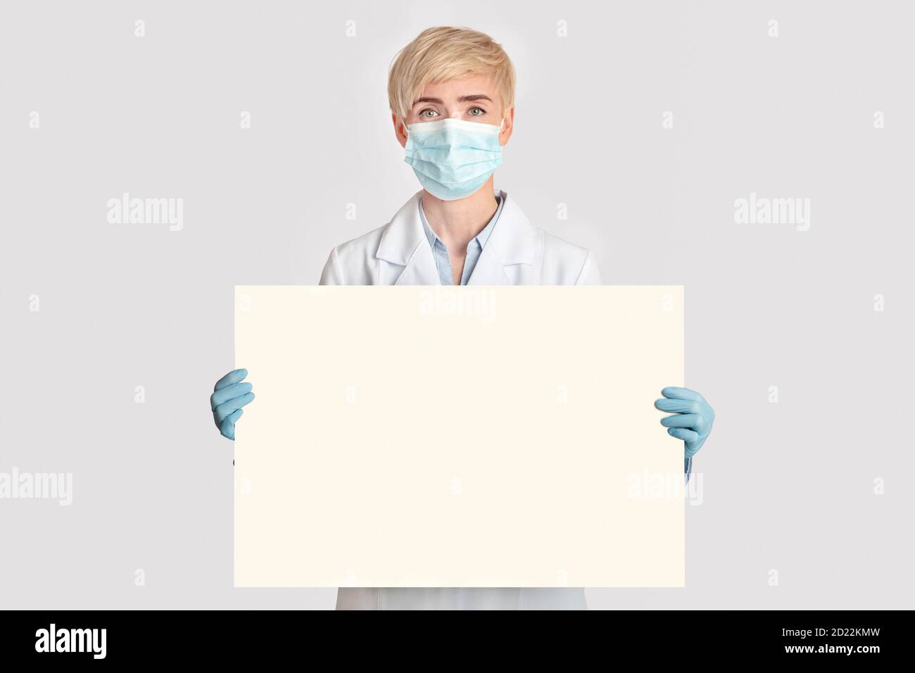 Salute, medicina e quarantena. Donna adulta medico tenendo poster con spazio libero Foto Stock