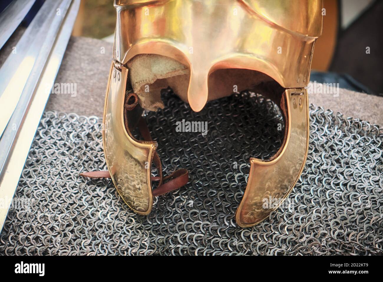 Antico vestito romano per una campagna militare. Casco giallo vintage giace sulla catena posta, primo piano. Casco in bronzo vero romano con fodera, stile di vita. Foto Stock