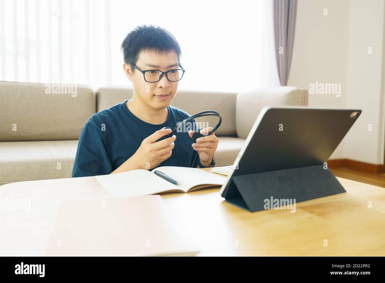 Uomo asiatico di 30-40 anni che usa il tablet, guardando la lezione corso online comunicare tramite videochiamata in conferenza da casa, concetto di formazione e-learning Foto Stock