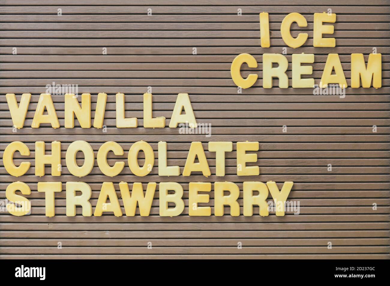 Cartello marrone vintage con il testo giallo gelato, vaniglia, cioccolato e fragola Foto Stock
