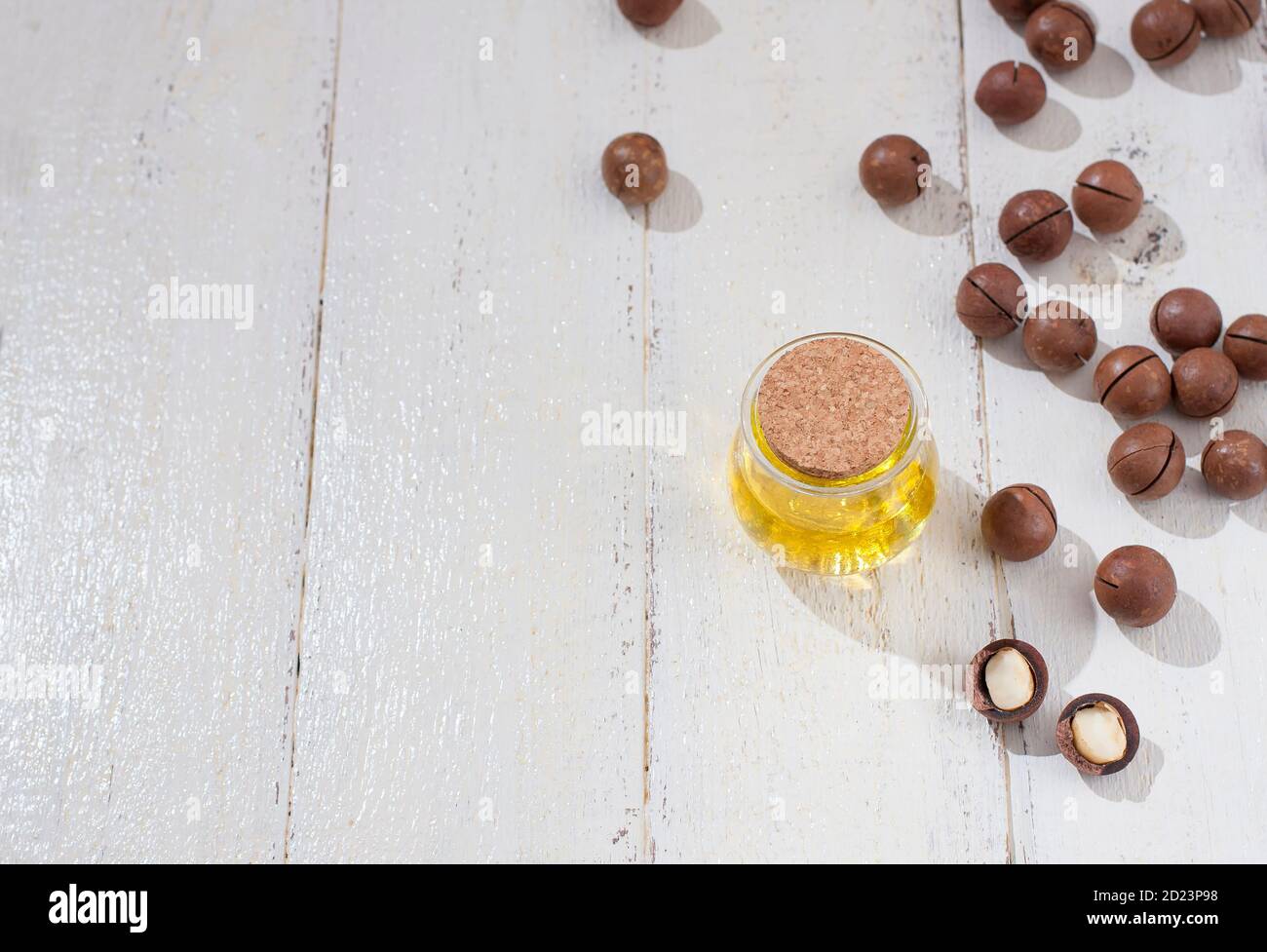 Olio di macadamia naturale e noci di Macadamia su tavola bianca di legno. Prodotto sano. Concetto di cibo sano. Foto Stock