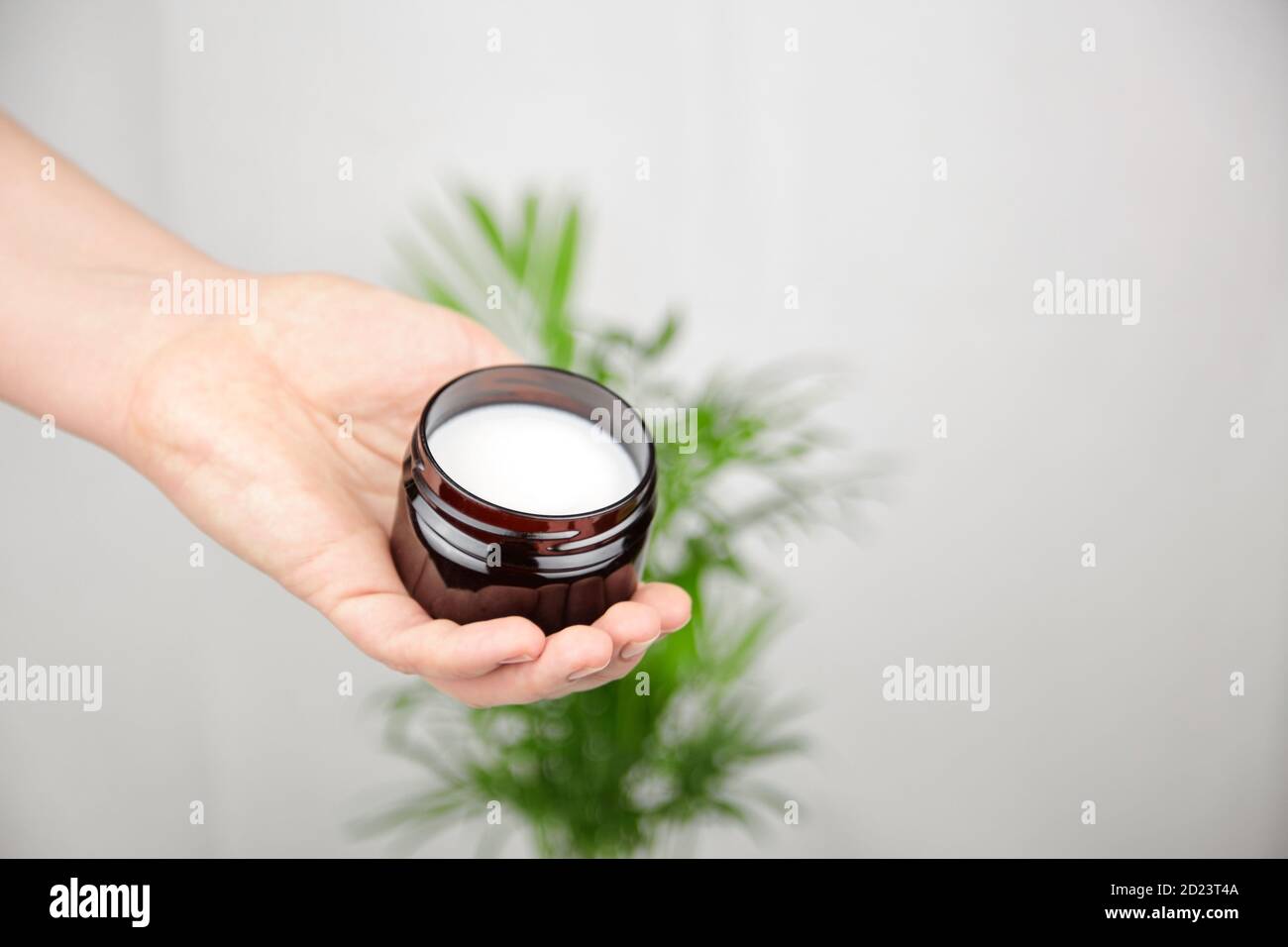 Vasetto di puro burro di karité a mano femminile, cosmetici naturali idratanti, prodotti per la cura della pelle e dei capelli. Trattamento anti-invecchiamento. Spazio di copia. Foto Stock