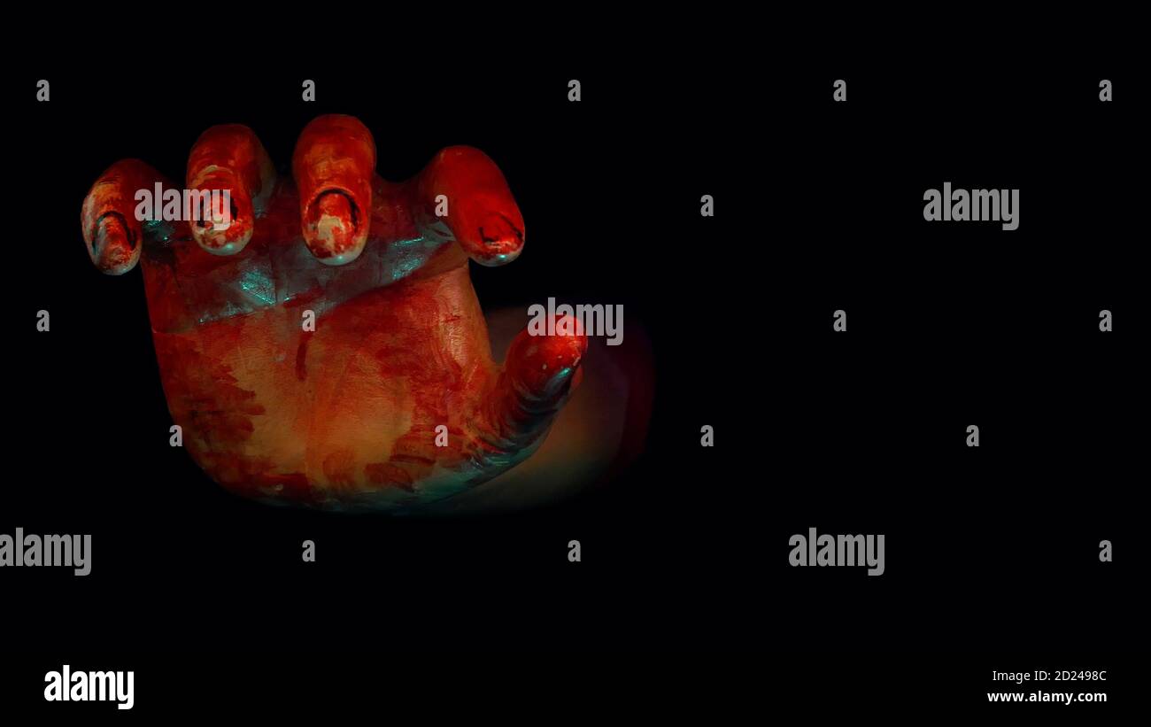 Una mano sanguinosa si stà fuori dallo spazio oscuro di Halloween notte infestata con scena horror Foto Stock