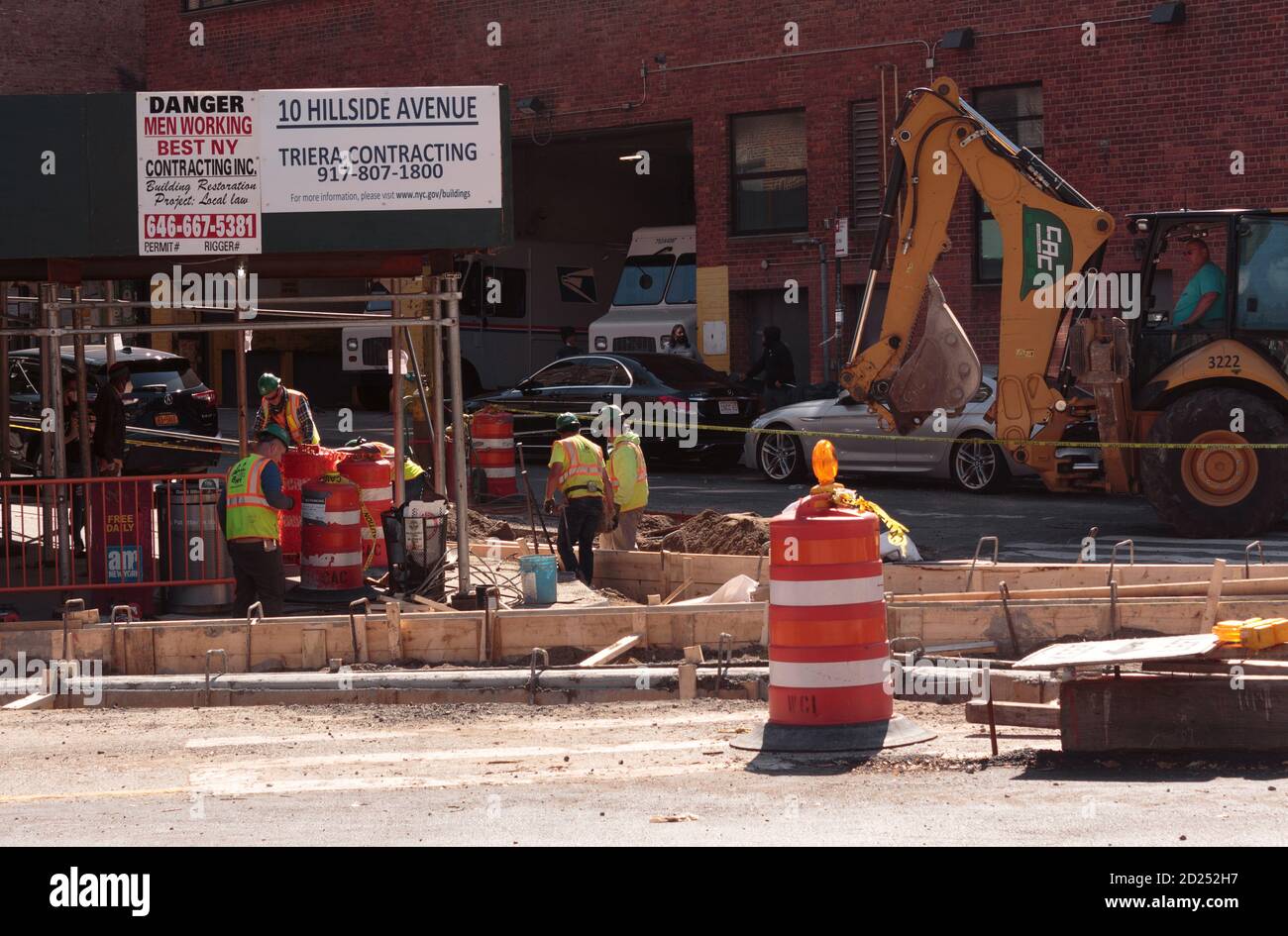 Uomini di costruzione al lavoro per lavori di riparazione di strada all'angolo di Broadway e Hillside Ave. A Northern Manhattan Foto Stock