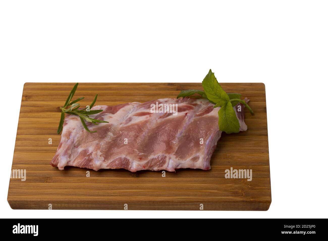 Vista ravvicinata delle costolette di maiale crudo sul taglio in legno ampio. Cucina e concetto di cibo. Foto Stock