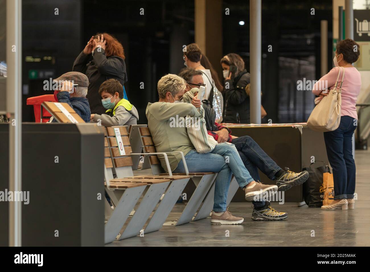 Saragozza, Spagna - 29 settembre 2020: Un gruppo di persone attende il treno alla stazione di Saragozza, cercando di rispettare le misure di allontanamento sociale i Foto Stock