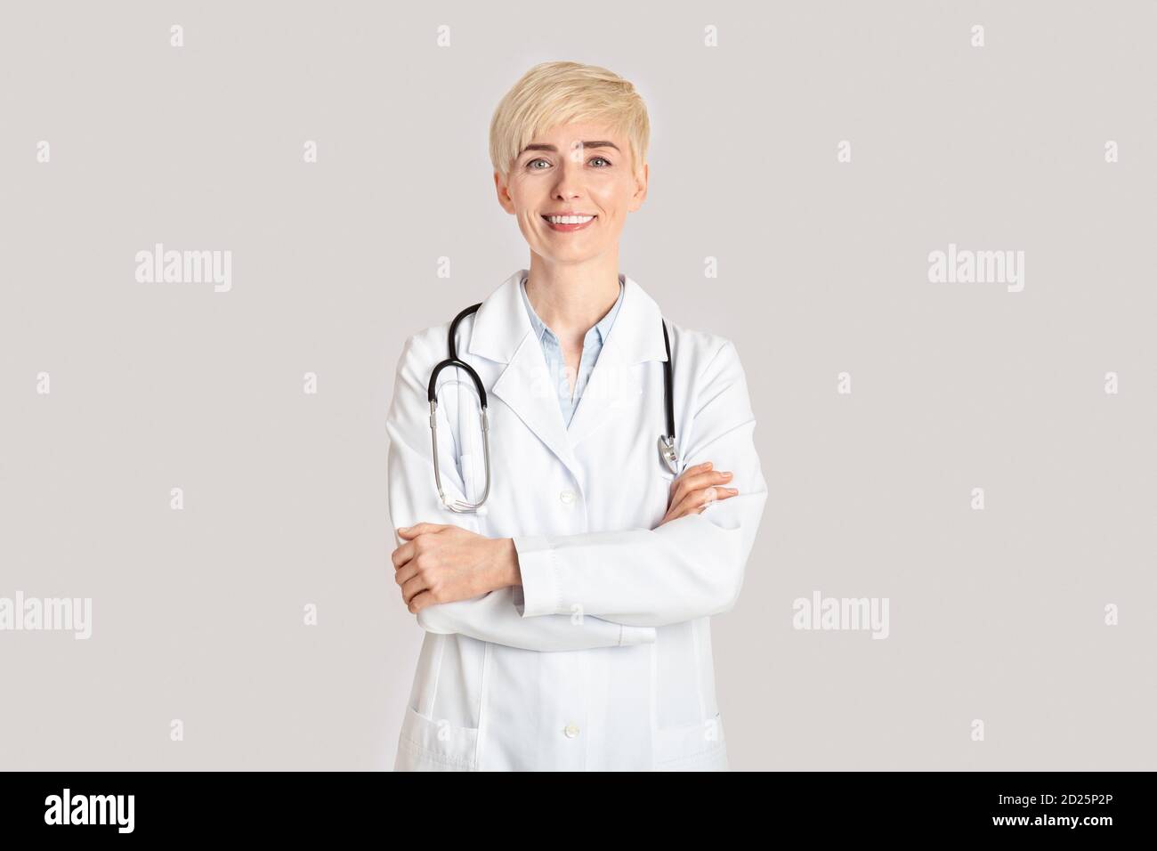 Medicina moderna e pratica privata. Allegro medico donna adulta ha attraversato le braccia Foto Stock