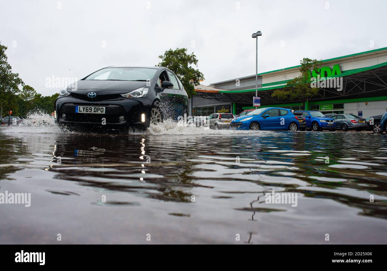 Parcheggio al dettaglio sommerso dopo forti downpoours. L'alluvione ha reso pericolosa la guida con alcuni proprietari di auto incapaci di accedere ai loro veicoli. Foto Stock