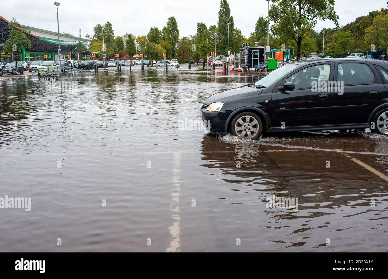 Parcheggio al dettaglio sommerso dopo forti downpoours. L'alluvione ha reso pericolosa la guida con alcuni proprietari di auto incapaci di accedere ai loro veicoli. Foto Stock